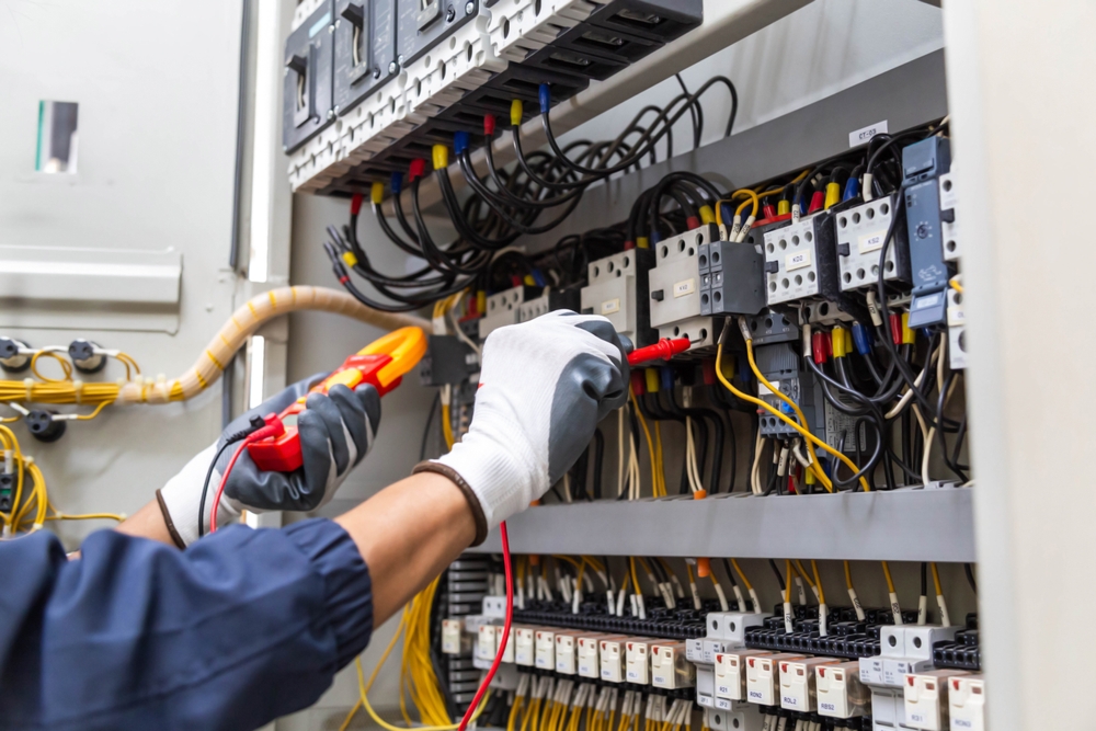 An engineer testing a panel with proper PPE NFPA 791 lewis bass blog example 1